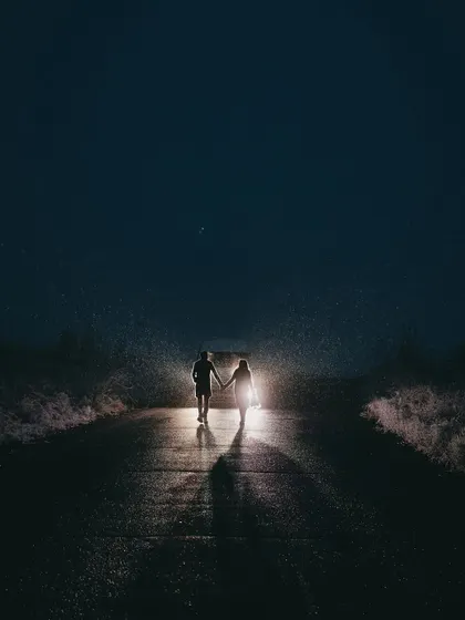 A cinematic night shot, where the couple becomes the center of their own universe. This creative pre-wedding photo uses dramatic lighting to create a sense of intimacy and adventure, proving that beautiful moments can be found long after the sun goes down.
