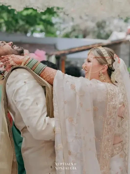 A playful moment between the couple, with the bride's beautifully stained arm and hand visible.