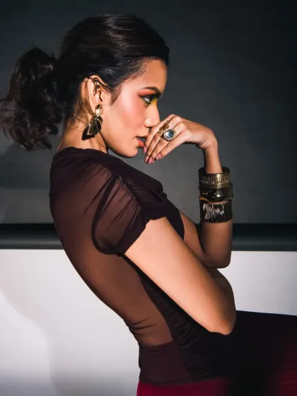 A profile shot that uses shadow and light to create a dramatic, high-fashion feel. The focus is on the model's form and the texture of the clothing.