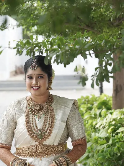 A happy bride, ready for her big day. The makeup is fresh and bright, perfect for an outdoor wedding setting.