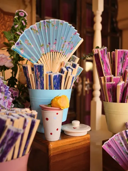 Colorful hand fans offered to guests to keep them comfortable during the outdoor welcome lunch in the desert heat.