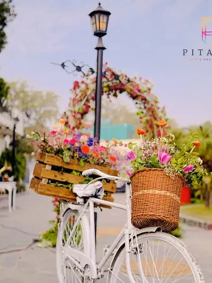 We love incorporating whimsical elements. This vintage white bicycle with baskets overflowing with colorful flowers served as a charming and unique decor piece for an outdoor event.