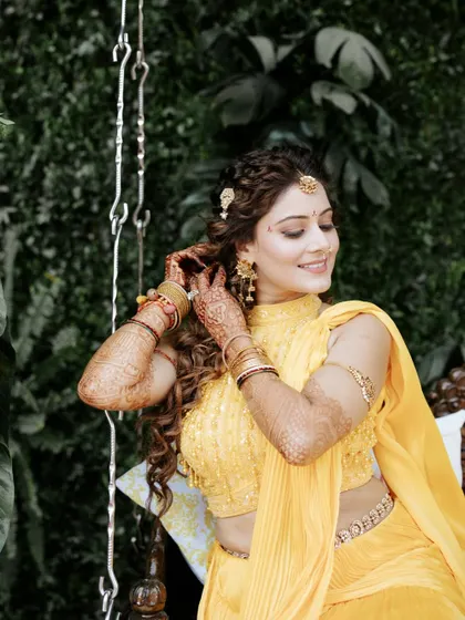 A close-up of the bride's detailed Haldi look, from her floral-inspired hairstyle to her delicate jewellery.