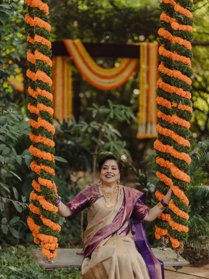 A guest enjoys the traditional floral swing (oonjal), a popular and beautiful feature at our events.