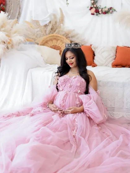 A duplicate of image 361, this beautiful portrait features a mom-to-be in a pink gown, seated in a romantic, boho-inspired setting.