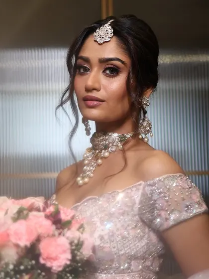 An ethereal and romantic bridal look with a soft pink gown and a bouquet of flowers, perfect for a Christian wedding or reception.