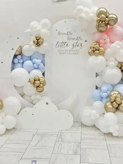 A dreamy "Twinkle Twinkle Little Star" theme, perfect for a gender-neutral baby shower or first birthday. The design uses a large crescent moon cutout backdrop, surrounded by soft clouds of pink, blue, and white balloons with pops of metallic gold. It’s a classic theme that I love to create.