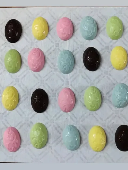 An assortment of my molded chocolate Easter eggs in various pastel colors and dark chocolate. They are perfect for Easter baskets or as a small, sweet gift.
