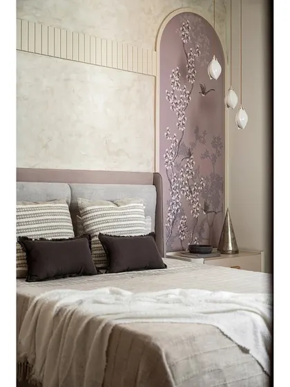 A close-up of the guest bedroom in 'The Boho Escape', showing the beautiful floral wallpaper arch and hanging pendant lights.