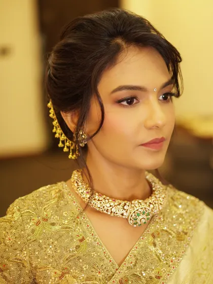 A moment of timeless elegance. This look for Geeth features a soft glow and flawless glam, creating a magical feel that perfectly complements her golden saree and traditional jewelry.