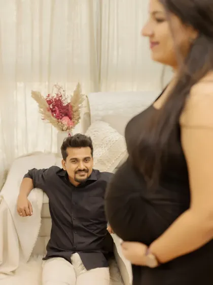 A creative shot focusing on the baby bump with your partner in the background. It tells a beautiful story of your shared journey and anticipation.