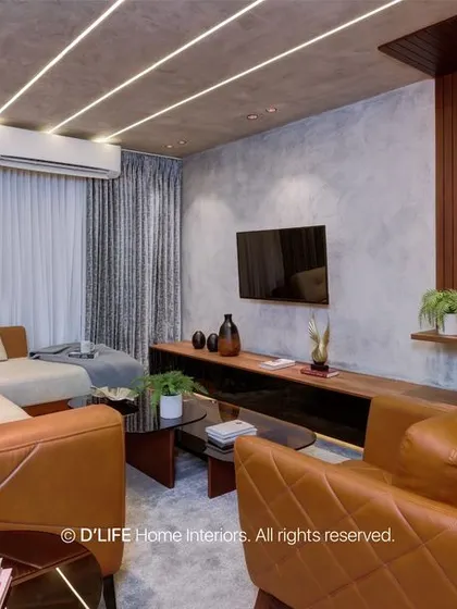 This living room uses a mix of textures, including wood paneling and a concrete-finish wall, to create a sophisticated and modern space. The leather sofa adds warmth and comfort.