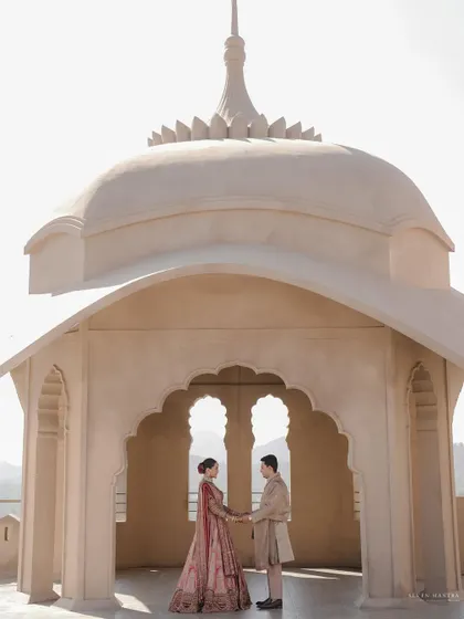 A classic portrait framed by stunning architecture. This image showcases the couple against the majestic backdrop of their wedding venue.