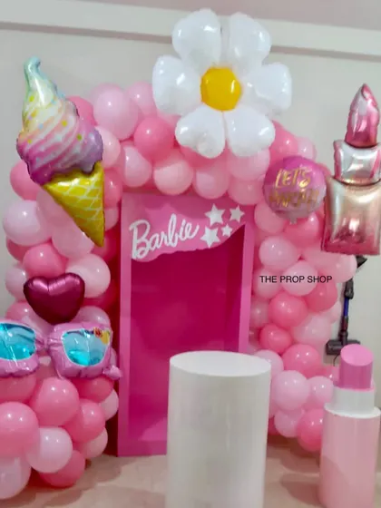 Our Barbie theme is all about the details. This setup includes a custom Barbie backdrop surrounded by a pink balloon arch and fun, oversized props like lipstick and sunglasses.