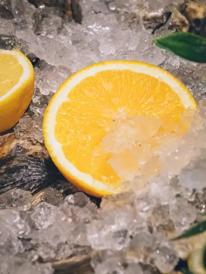 A refreshing slice of orange on ice, representing our fresh ingredients.