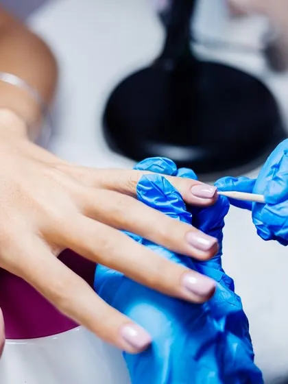 The art of gel application. Our technician carefully applies gel polish, which is then cured under a UV light for a durable, glossy, and long-lasting finish.