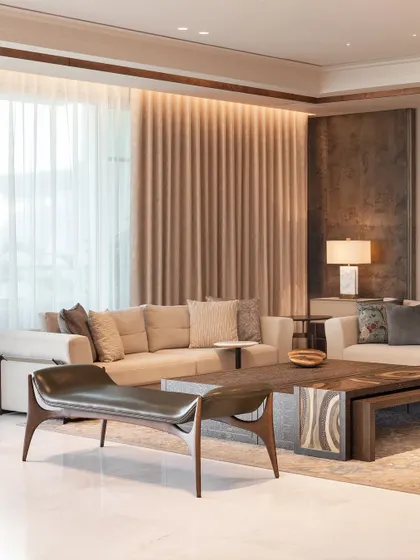 A study in texture and tone, this living room combines soft fabrics, rich wood, and sculptural metal. A sleek metallic bench adds an artistic and unexpected element to the seating arrangement, demonstrating how custom furniture can elevate a space beyond the conventional.