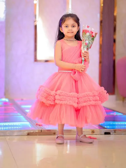 The birthday girl holding a bouquet of flowers, looking like a little princess.