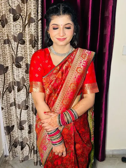 The bride's complete look, showing the beautiful details of her saree and the subtle, elegant makeup.