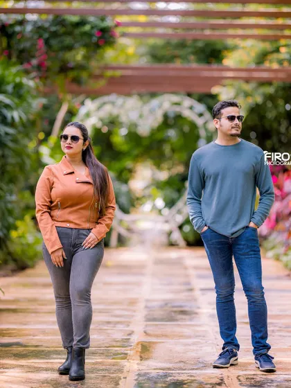 A modern, editorial-style shot on a garden path. The couple poses with a cool, confident attitude, showcasing their individual style.