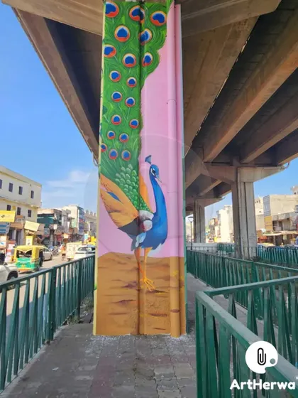 A majestic peacock mural painted on a pillar in Chandigarh. This piece celebrates India's national bird with rich, detailed feathers against a soft pink background.