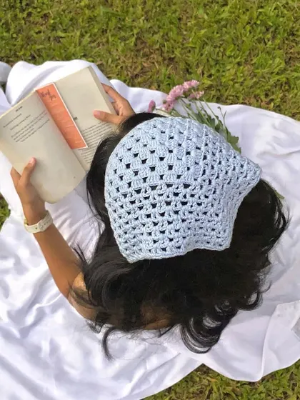 A dreamy picnic scene featuring our handmade blue crochet bandana. It's the perfect accessory for a soft girl or cottagecore look.