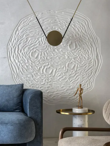 A close-up of the custom wall art in the Slender House living room. The textured, organic form creates a focal point that contrasts beautifully with the smooth, neutral walls, emphasizing quality of craft over quantity of objects.