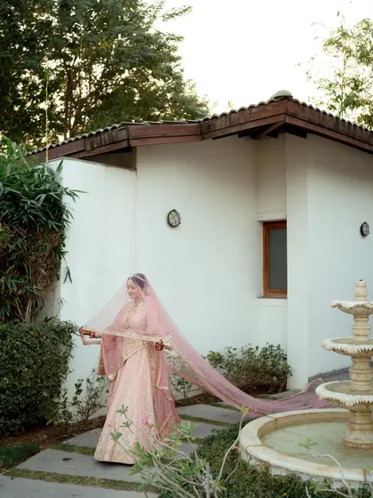An elegant portrait of the bride, Kaushani, with her long, flowing veil creating a beautiful sense of movement.