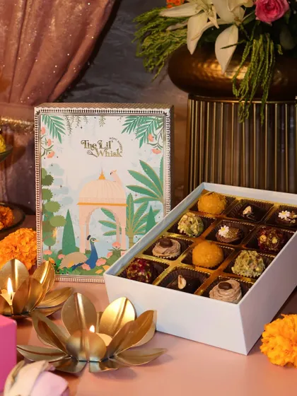 The Peacock Paradise sweets box is also available in this elegant white and blue design. Both versions are filled with the same delicious assortment of Motichoor truffles, Coffee Barfis, and more.