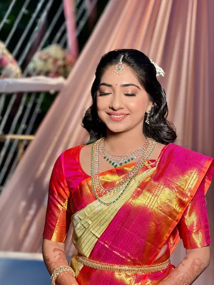The makeup for this look features soft, shimmery eyeshadow and a natural lip color, creating a dreamy and romantic feel that complements her beautiful saree.