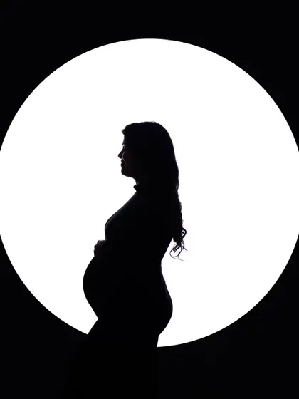 Sometimes, the most powerful stories are told in silhouette. This classic black and white portrait uses dramatic lighting to emphasize the beautiful curve of the baby bump, creating an iconic and artistic image that is both intimate and profound.