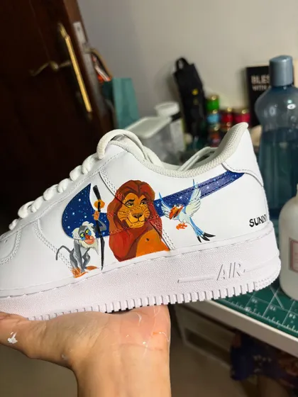 A classic Disney scene from The Lion King, hand-painted on the Nike swoosh of these custom Air Force 1s.