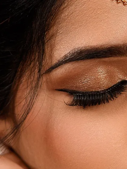 A detailed shot of a classic golden glitter eye makeup. This look is perfect for brides who want a touch of glamour and sparkle for their big day.