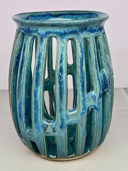 This carved tea light holder has a beautiful turquoise glaze that pools and breaks over the texture, creating a lot of depth and interest.