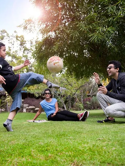 A father and son share a high-kick playing football on our lawn. We provide the space for families to play freely and make energetic, happy memories.