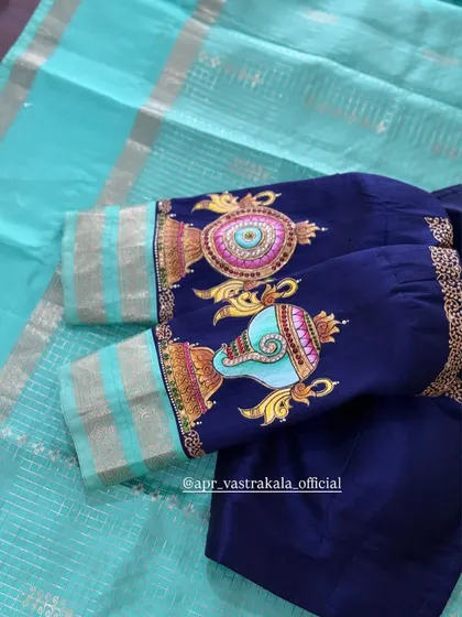 A view of the sleeves of the navy blue blouse, showing both the shankh and chakra paintings.
