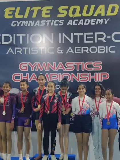 The girls' team with their parents on the podium. The support from families is a crucial part of our gymnasts' success.