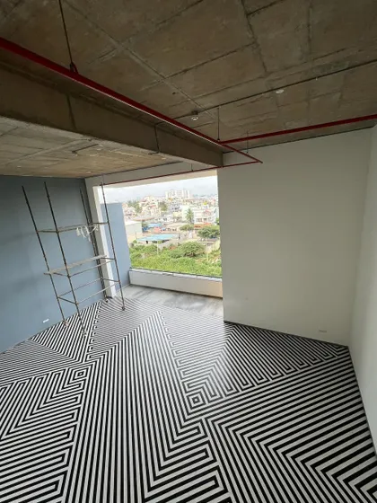 The social core of 'The Treehouse' apartments features a double-height lounge with a striking black and white geometric floor pattern. This space serves as a central hub, visually and functionally connecting different amenities and residential floors.