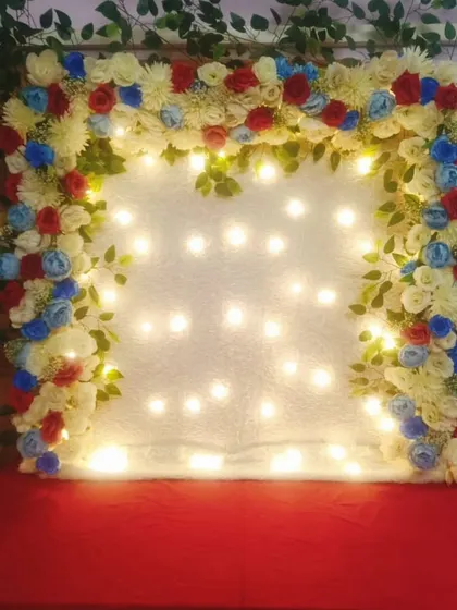 This floral frame uses a unique color combination of red, white, and blue artificial flowers. Paired with a backdrop of fairy lights, it creates a bright and sparkling effect that is both festive and different.