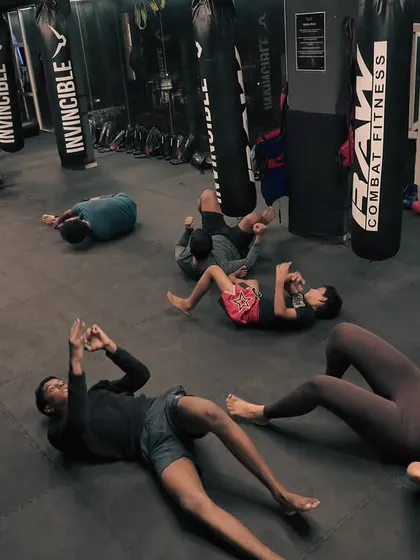 Core work is a constant. A wide shot of the class engaged in various floor exercises to build abdominal strength and endurance.