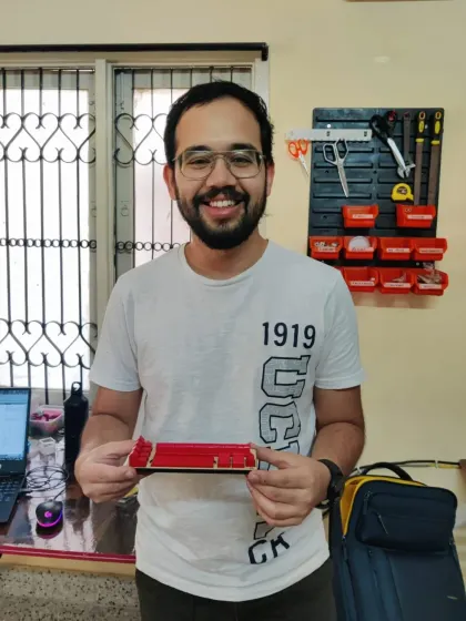 The proud maker holding his laser cut Catan piece holder. A perfect example of using our lab to enhance your hobbies.