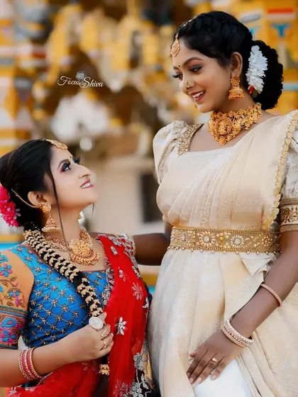 A beautiful example of coordinated outfits for a photoshoot, featuring two different styles of traditional South Indian half sarees that complement each other perfectly.