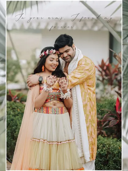 The bride shows off her henna-adorned hands while sharing a warm embrace with her groom, a perfect blend of tradition and romance.