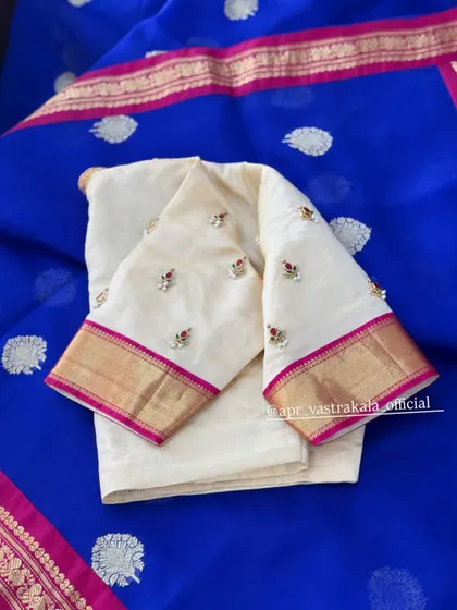 The subtle red butis add a hint of color to the off-white fabric.