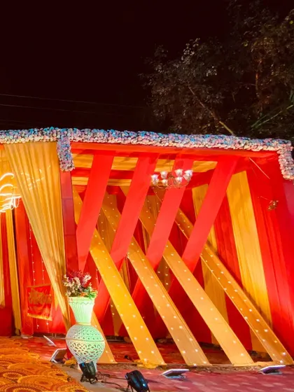 A side structure featuring a creative use of red and yellow fabric strips, adding a modern design element to the event space.