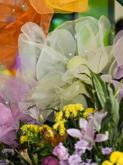 Another detail of the whimsical fabric flowers, showing their soft texture and pastel colors.
