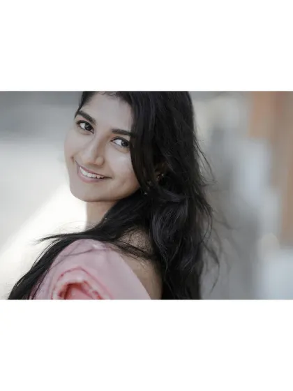 A bright and happy portrait with a beautiful smile. The over-the-shoulder pose feels natural and engaging, capturing a moment of pure, simple joy.