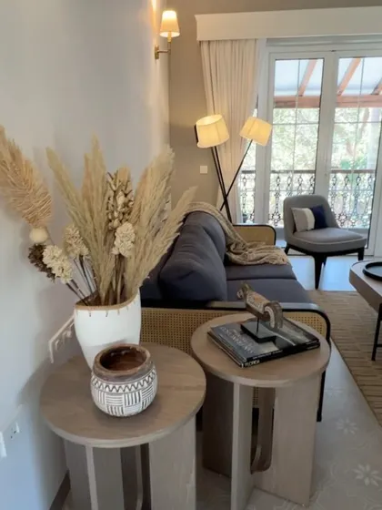 The TV lounge at Chikkoo Villa in Goa, featuring a versatile sofa-cum-bed with rattan and fabric details. The space is designed to be both functional and stylish, with a relaxed, coastal vibe.