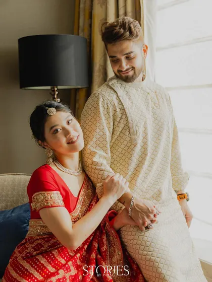 A candid and sweet moment captured by the window. This photo shows the couple's natural interaction and affection, using soft, natural light to create a gentle and romantic scene.