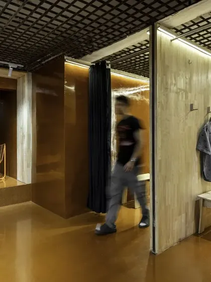 The changing room area, designed for comfort and privacy while maintaining the store's industrial and warm material palette.